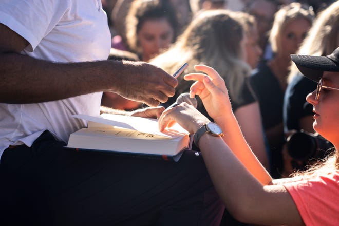 GOP presidential candidate Vivek Ramaswamy signs a copy of his book during Gov. Kim Reynolds' Fair-Side Chat during day three of the Iowa State Fair on Saturday, August 12, 2023 in Des Moines.