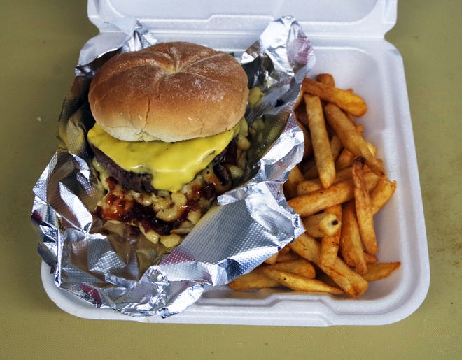 The Monster Burger with mac and cheese, BBQ sauce and fries is served up at the Bobcats Food truck on Friday, Nov. 3, 2023 in Taunton.