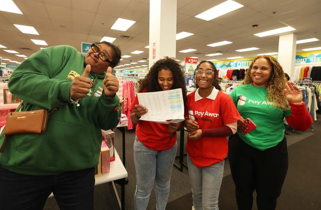 Customer Jaijai Mednes, left, at a holiday payoff event at Brockton Citi Trends on Tuesday, Dec. 12, 2023. Customers had their layaway items paid off from a partnership between the nonprofit Pay Away and Brown.