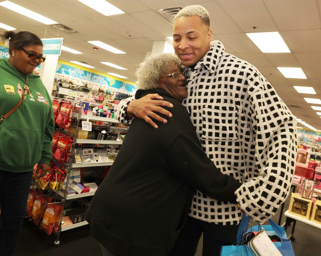 Customer Janis Williams hugs New England Patriots tight end Pharaoh Brown with Jaijai Mendes, left, at a surprise holiday payoff event at Brockton Citi Trends on Tuesday, Dec. 12, 2023. Customers had their layaway items paid off from a partnership between the nonprofit Pay Away and Brown.