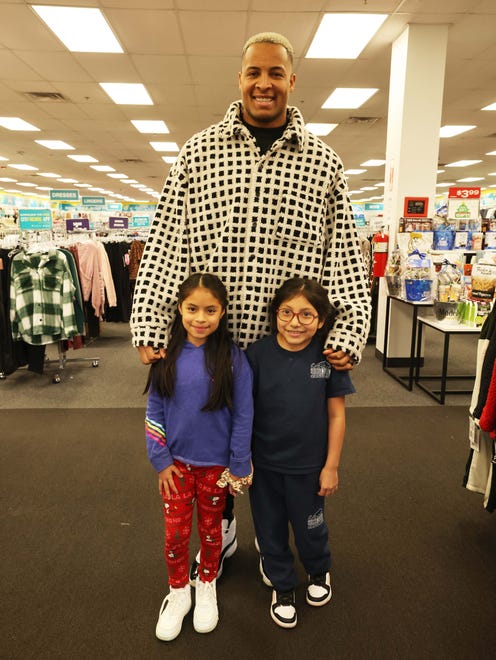 Customers Jhoanna Castro, 10, left, and Evelyn Chimbay, 7, with New England Patriots tight end Pharaoh Brown for surprise holiday payoff event at Brockton Citi Trends on Tuesday, Dec. 12, 2023. Customers had their layaway items paid off from a partnership between the nonprofit Pay Away and Brown.