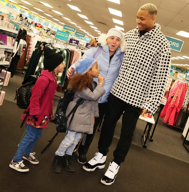 Customer Nicole Miller, Arianna Moniz, 9, and Amadeia Moniz, 6, with New England Patriots tight end Pharaoh Brown at a surprise holiday payoff event at Brockton Citi Trends on Tuesday, Dec. 12, 2023. Customers had their layaway items paid off from a partnership between the nonprofit Pay Away and Brown.