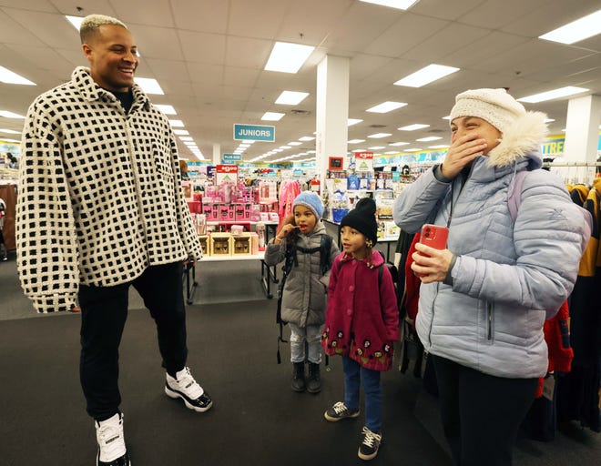 Customer Nicole Miller, Arianna Moniz, 9, and Amadeia Moniz, 6, with New England Patriots tight end Pharaoh Brown at a surprise holiday payoff event at Brockton Citi Trends on Tuesday, Dec. 12, 2023. Customers had their layaway items paid off from a partnership between the nonprofit Pay Away and Brown.