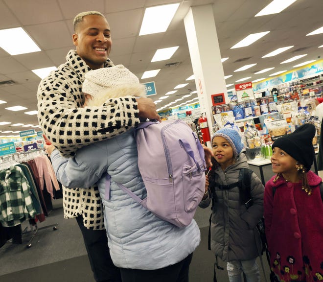 Customer Nicole Miller and Arianna Moniz, 9, and Amadeia Moniz, 6, with New England Patriots tight end Pharaoh Brown at a surprise holiday payoff event at Brockton City Trends on Tuesday, Dec. 12, 2023. Customers had their layaway items paid off.