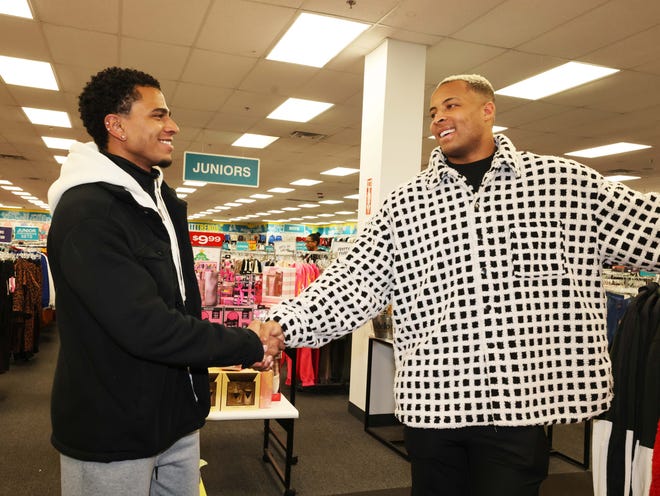 Customer Jason, left, thanks New England Patriots tight end Pharaoh Brown at a surprise holiday payoff event at Brockton City Trends on Tuesday, Dec. 12, 2023. Customers had their layaway items paid off from a partnership between the nonprofit Pay Away and Brown.