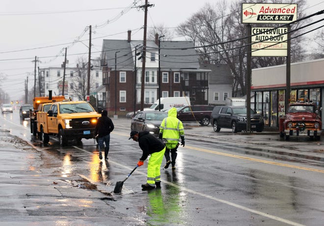 Brockton Department of Public Work employees clean a storm drain on Main Street during a storm on Monday, Dec. 18, 2023.