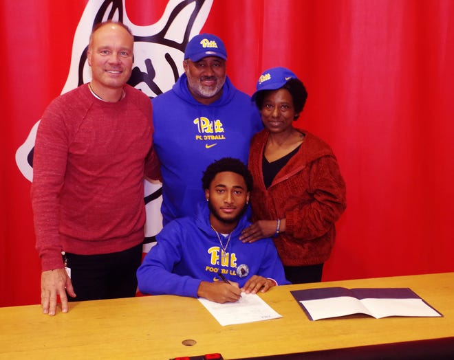 Brockton High Athletic Director Kevin Karo, left, joins Cameron Monteiro and Monteiro's parents, Jose and Renee, on Wednesday, Dec. 20, 2023. Cameron Monteiro, a 6-3 three-star receiver, signed his national letter of intent to play football at Pitt.