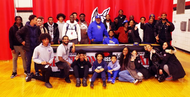 Friends, family, and former coaches gather round Brockton High's Cameron Monteiro (seated at table) on Wednesday, Dec. 20, 2023, after he signed his national letter of intent for Pitt football in 2024 to play wide receiver for the Panthers.